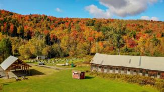 A drone Image of Atkins Field, the 15 acres of green space in downtown Hardwick, owned by CAE. This image shows the new pavilion, the old granite shed, community gardens, and fall foliage. 